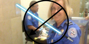 A TSA check point with a "no lightsabers" image superimposed over it.