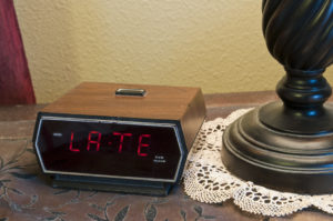 Old fashioned digital alarm clock showing "late" on the display. 