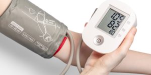 An at home blood pressure monitor being used to take a measurement.