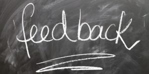 Chalkboard with the word "feedback" written on it with chalk and underlined.